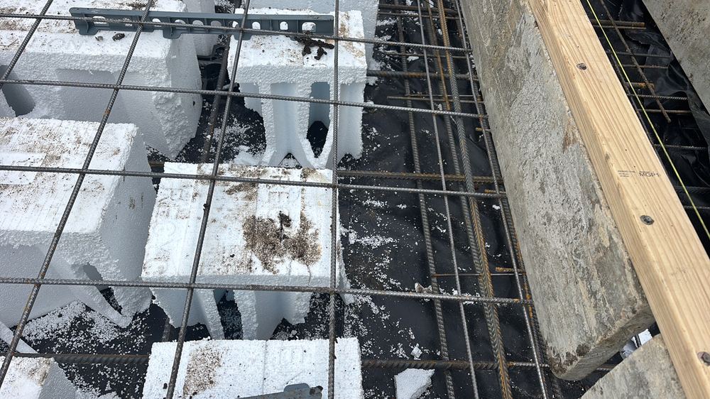 Reinforcement needing loose rust and mud cleaned off before the pour, found during a construction stage inspection in Wollert
